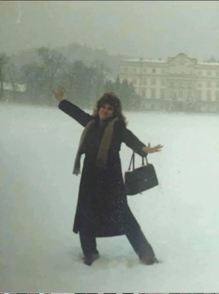 Darcy Ellen standing in the snow with her arms outstretched